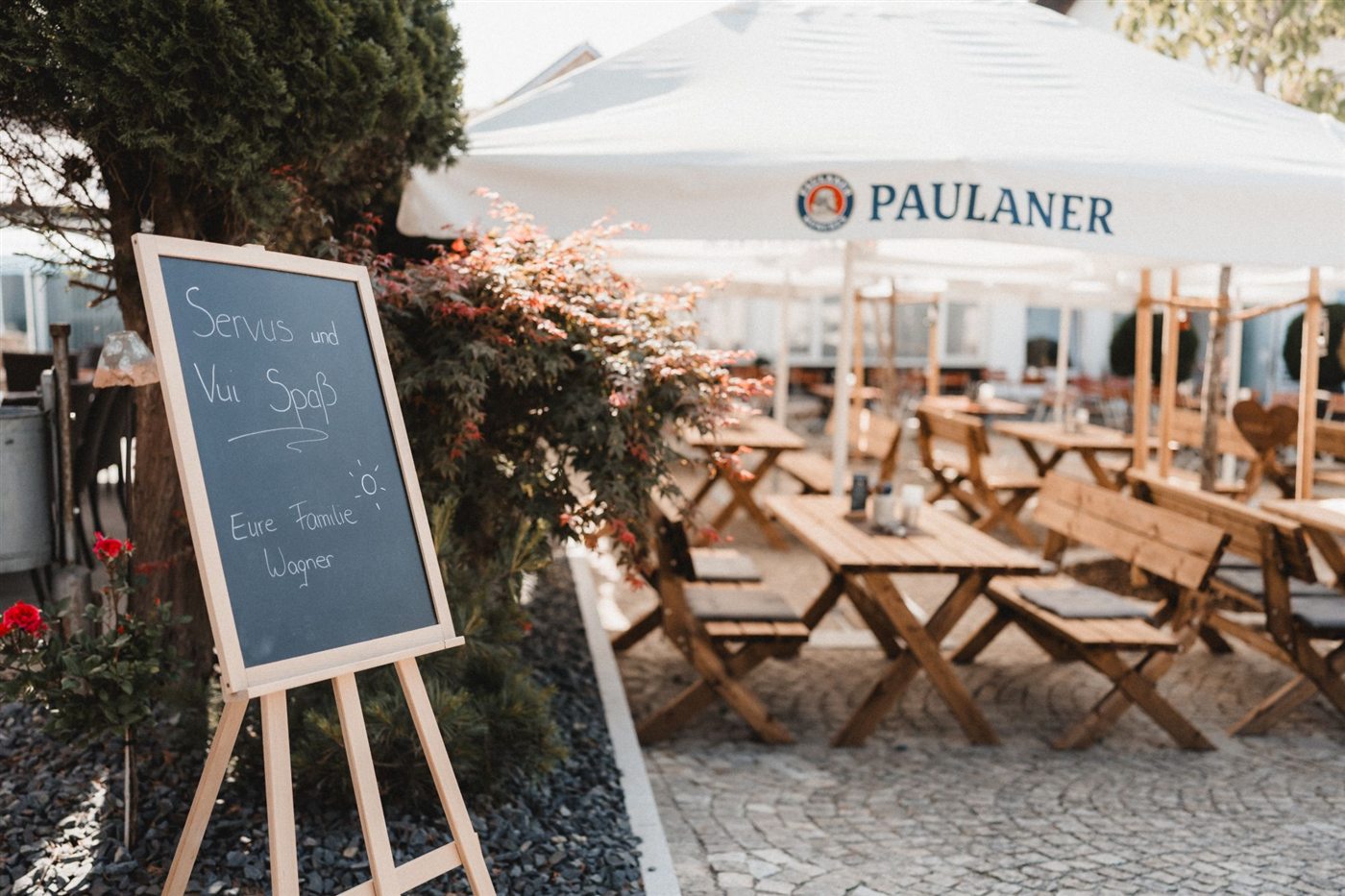 Biergarten mit Tafel „Servus und Vui Spaß – Eure Familie Wagner“