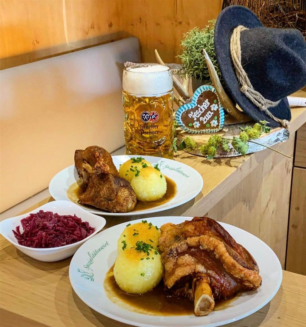 Schweinshaxn und knusprige Ente mit Knödeln und Blaukraut, dazu eine Maß Hacker-Pschorr