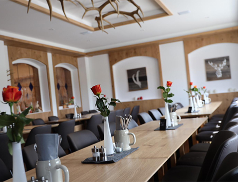 Jägerstube mit Hirschgeweih und langer Tafel